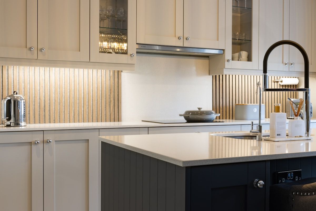 Light kitchen with shaker cabinets and a dark island.