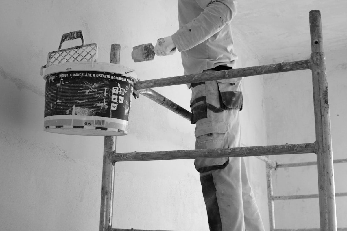 Painter rolling paint on an interior wall.
